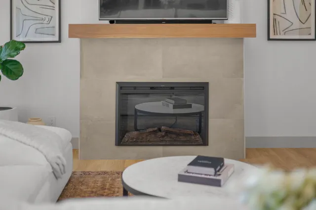 a living room with furniture a fireplace and a flat screen tv