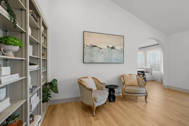 a living room with furniture and a wall painting