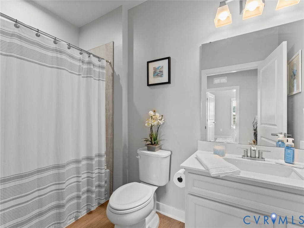 6725 Citory Way, Unit 202 Moseley, VA 23120 - Photo 33 of 42 a bathroom with a sink a toilet a mirror and shower curtain