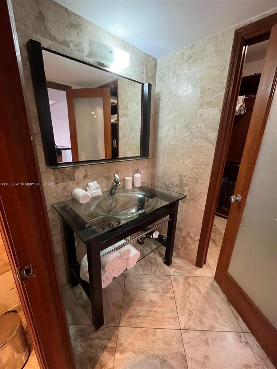 2301 Collins Avenue, Unit 731 Miami Beach, FL 33139 - Photo 18 of 31 a bathroom with a sink and a mirror