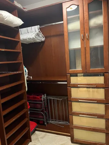 a view of walk in closet with clothes and shoes