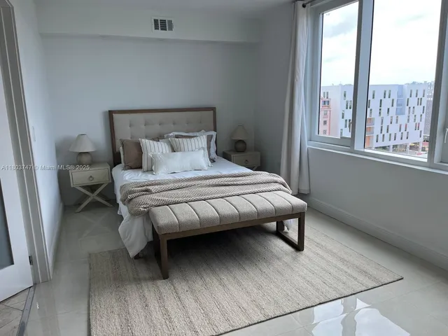 a bedroom with a bed wooden floor and window