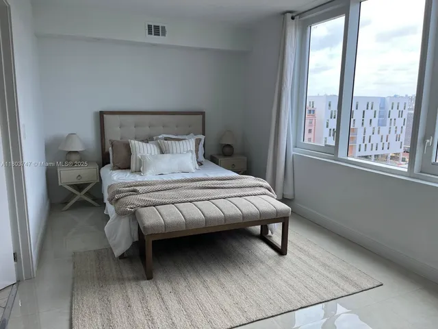 a bedroom with a bed wooden floor and window