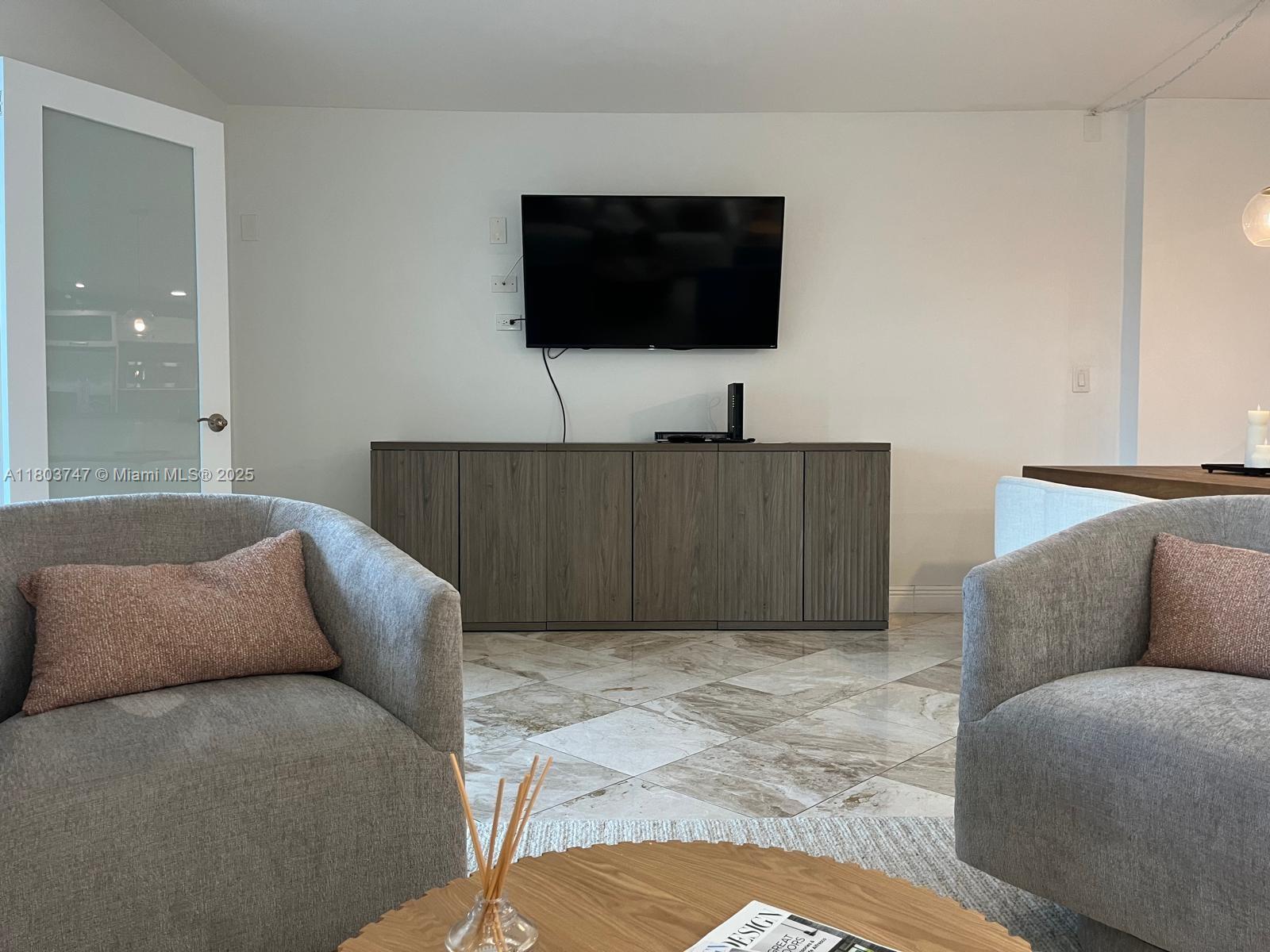 2301 Collins Avenue, Unit 731 Miami Beach, FL 33139 - Photo 4 of 31 a living room with furniture and a flat screen tv