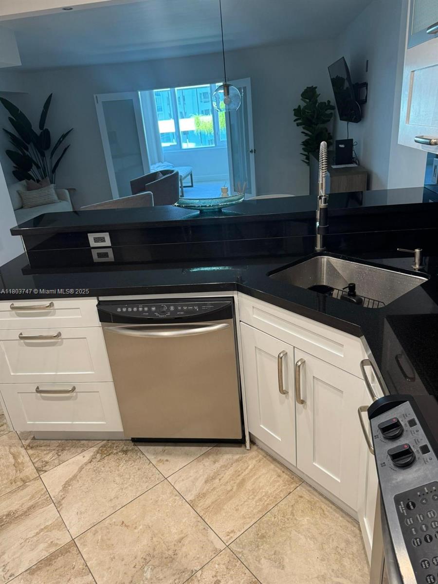 2301 Collins Avenue, Unit 731 Miami Beach, FL 33139 - Photo 8 of 31 a kitchen with granite countertop a stove a sink a microwave and cabinets