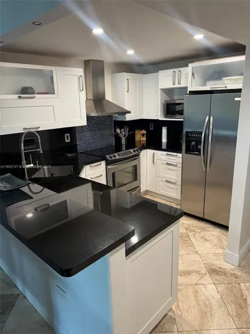 a kitchen with stainless steel appliances granite countertop a sink and a stove