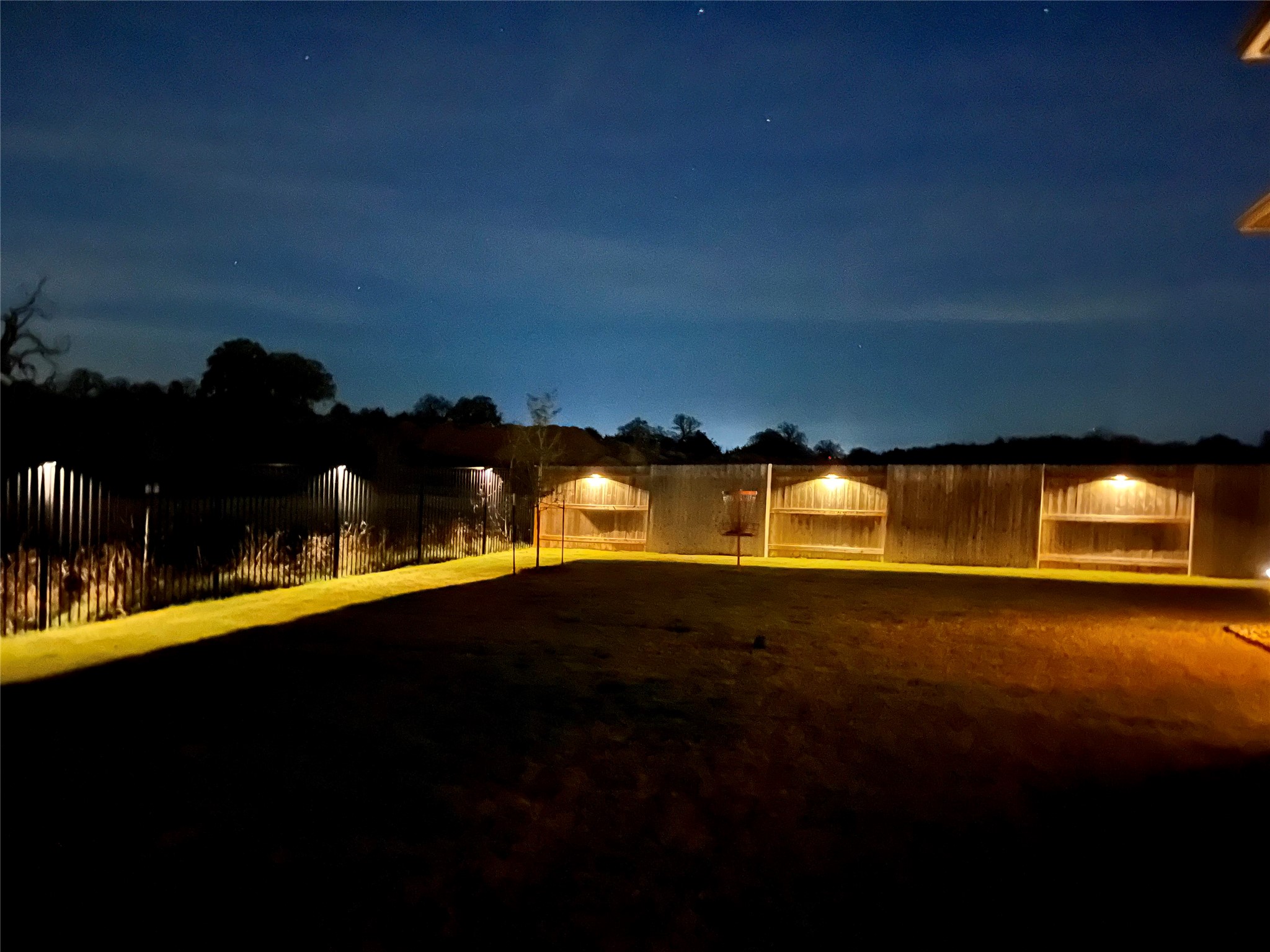 130 Firethorn Loop Bastrop, TX 78602 - Photo 37 of 38 Secure yard featuring a well-maintained fence and ample outdoor lighting for evening enjoyment.