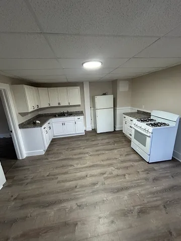 a kitchen with stainless steel appliances wooden cabinets and wooden floor