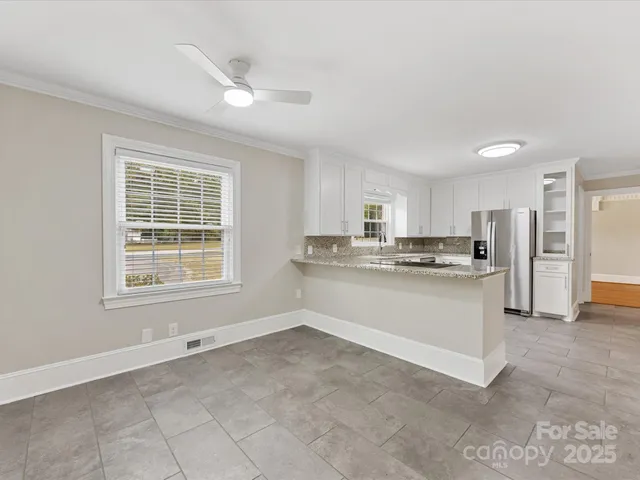 a kitchen with a refrigerator and white cabinets