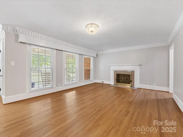 a view of empty room with wooden floor and fireplace