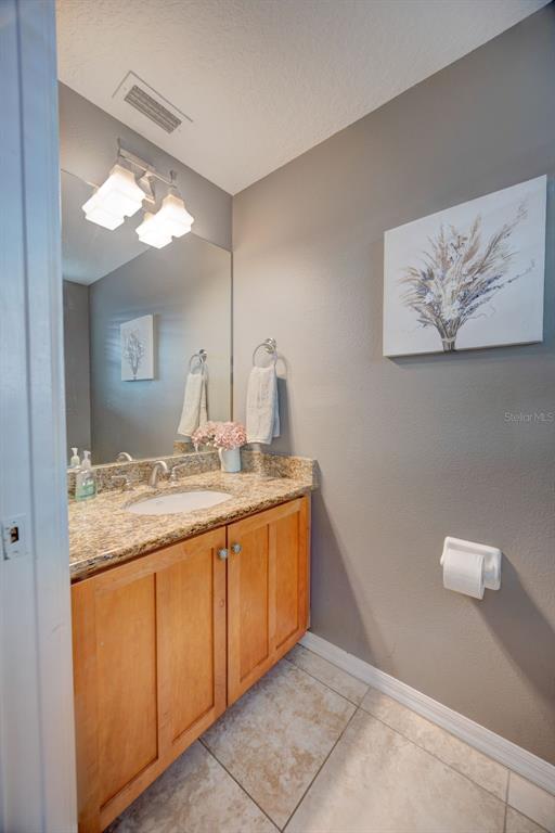 6020 Fishhawk Crossing Boulevard Lithia, FL 33547 - Photo 44 of 53 a bathroom with a granite countertop sink a mirror and a vanity