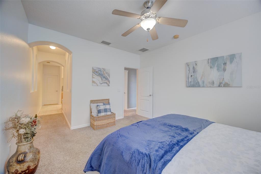 6020 Fishhawk Crossing Boulevard Lithia, FL 33547 - Photo 6 of 53 a bedroom with a large bed and a chandelier