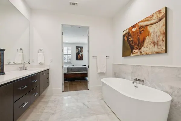 a spacious bathroom with a tub sink and mirror