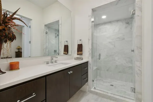 a bathroom with a double vanity sink mirror and shower