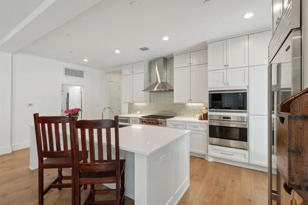 a kitchen with a table chairs microwave and cabinets