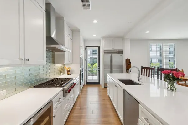 a kitchen with stainless steel appliances a sink stove and cabinets