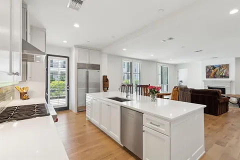 a kitchen with stainless steel appliances kitchen island granite countertop a refrigerator and a stove