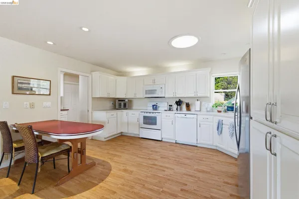a kitchen with white cabinets and stainless steel appliances