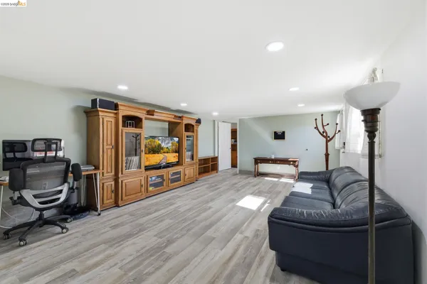 a kitchen with stainless steel appliances granite countertop a stove top oven a sink a dining table and chairs with wooden floor