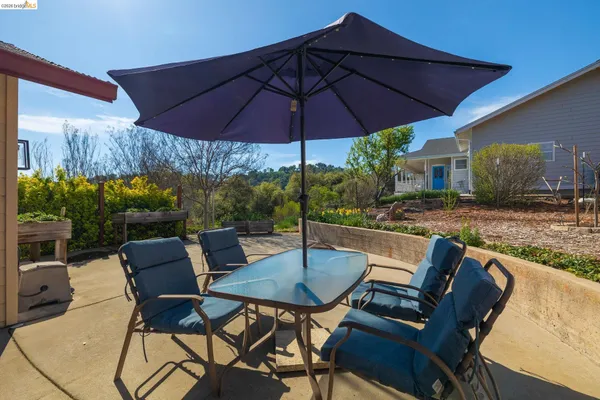 a patio with a table and chairs under an umbrella