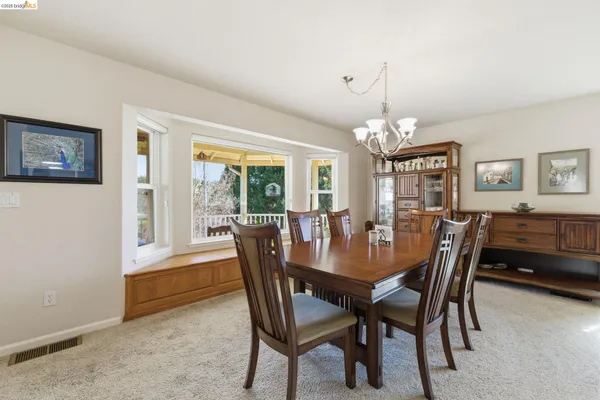 a view of a dining room with furniture and a chandelier