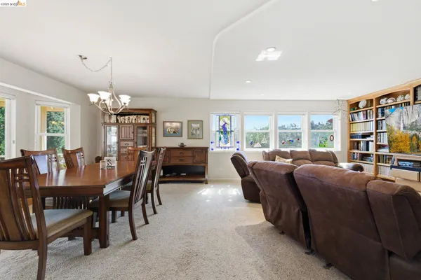 a living room with furniture a bookshelf and a large window