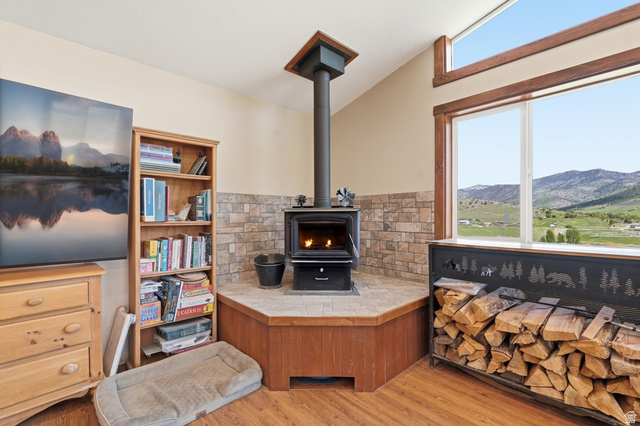 8066 North Valley View Heights Preston, ID 83263 - Photo 7 of 34 Corner wood-burning stove with a stone tile surround and a wood-finish hearth