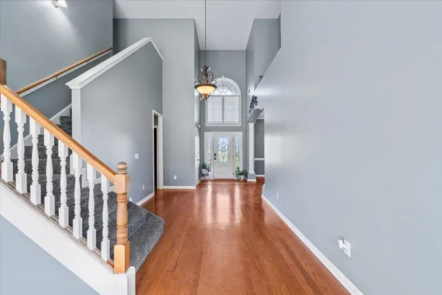 a view of a hallway with wooden floor and staircase