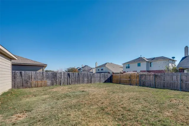 a front view of a house with a yard and wooden fence
