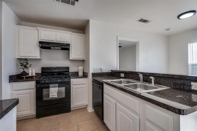 a kitchen with stainless steel appliances granite countertop a sink stove and cabinets