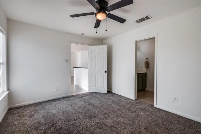 an empty room with closet and a chandelier fan