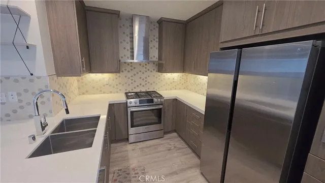a kitchen with stainless steel appliances a refrigerator sink and stove
