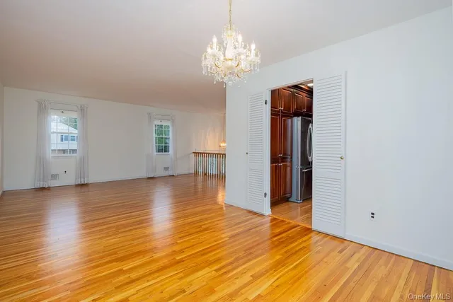 a view of a livingroom with wooden floor and a chandelier