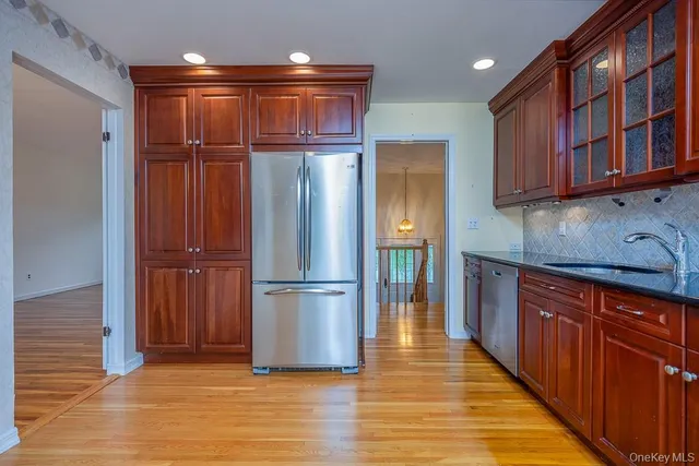 a kitchen with stainless steel appliances granite countertop a refrigerator and a sink