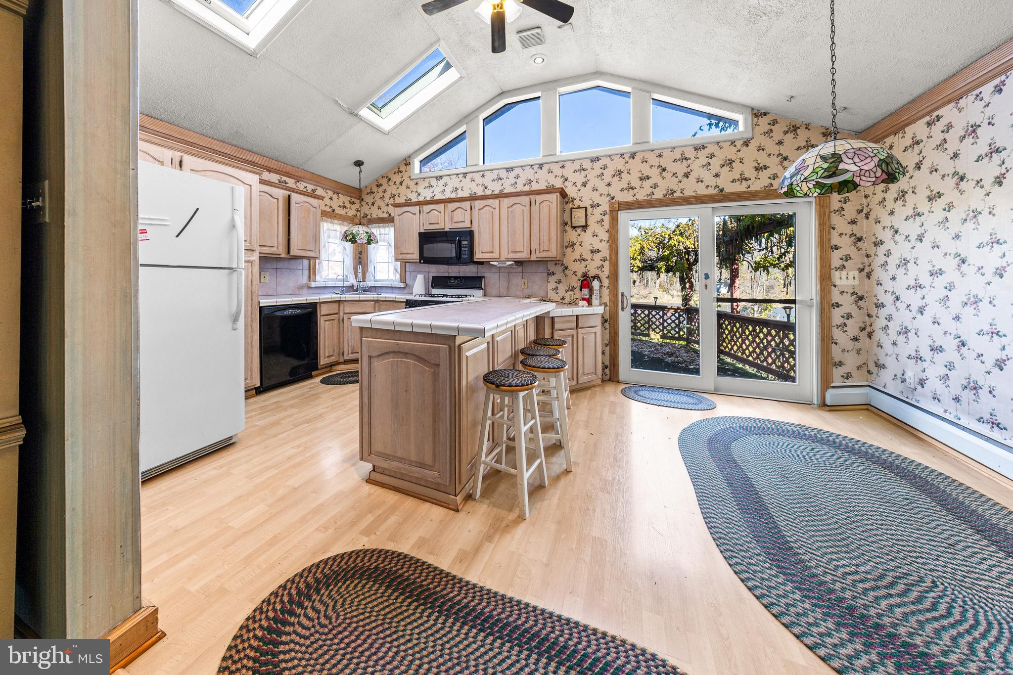 509 Neshaminy Road Croydon, PA 19021 - Photo 13 of 16 a open kitchen with stainless steel appliances granite countertop a stove top oven a refrigerator a sink dishwasher with a dining table and chairs with wooden floor