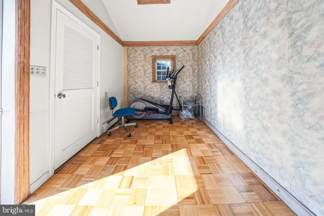 a view of a hallway with wooden floor and a bathroom