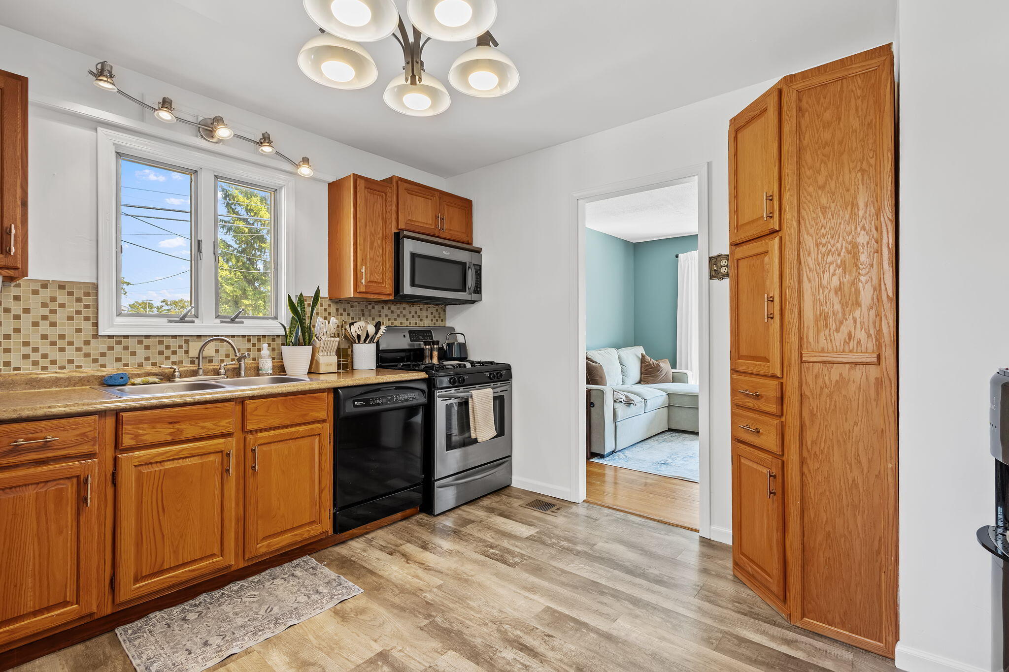 810 East Grace Street Rensselaer, IN 47978 - Photo 5 of 17 a kitchen with stainless steel appliances granite countertop a stove top oven a sink dishwasher a dining table and chairs with wooden floor