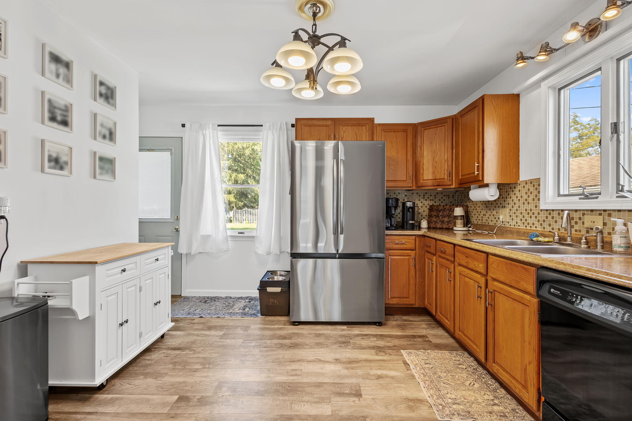 810 East Grace Street Rensselaer, IN 47978 - Photo 6 of 17 a kitchen with stainless steel appliances granite countertop a refrigerator a sink dishwasher a dining table and chairs with wooden floor