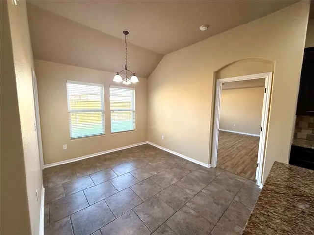 a kitchen with kitchen island granite countertop wooden cabinets a refrigerator and a sink