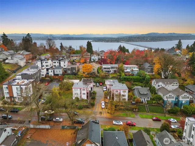 a view of a white house with a small yard and potted plants