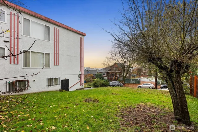 a view of a house with backyard and a tree