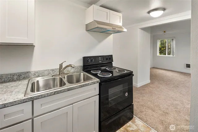 a kitchen with stainless steel appliances granite countertop white cabinets and a stove