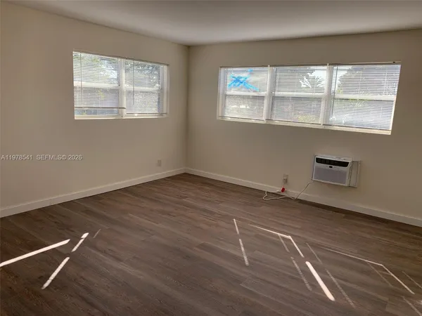 a view of a room with wooden floor and window