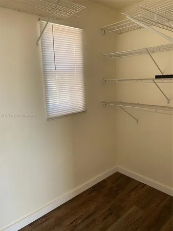 a view of a small space with wooden floor and a window