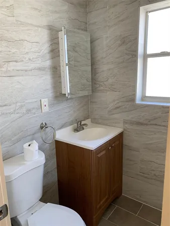 a bathroom with a sink a toilet and a window