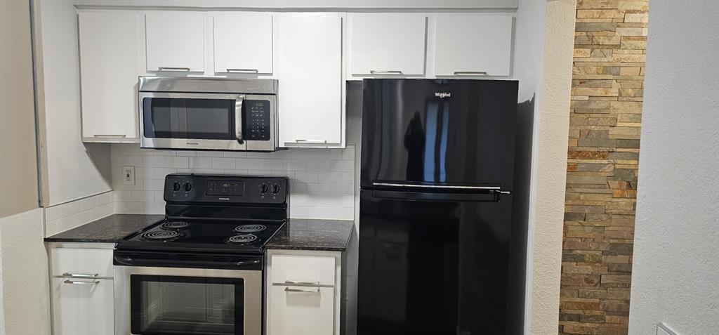 4845 Cedar Springs Road, Unit 167 Dallas, TX 75219 - Photo 3 of 10 a kitchen with granite countertop a stove and a refrigerator