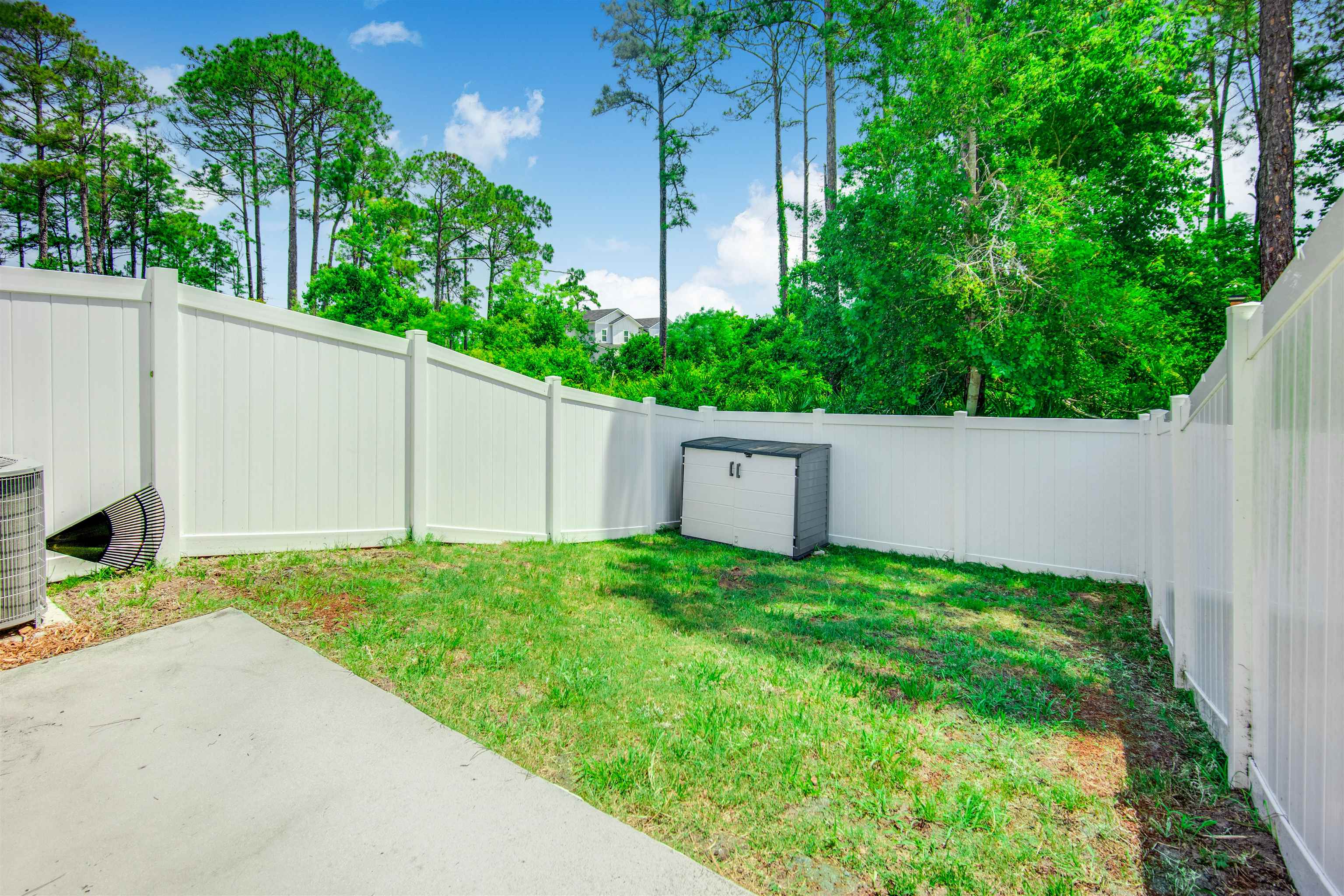 98 Ridge Lake Road St. Augustine, FL 32086 - Photo 25 of 31 a view of a backyard with potted plants and a large tree