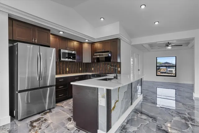 a kitchen with stainless steel appliances a refrigerator and a stove top oven