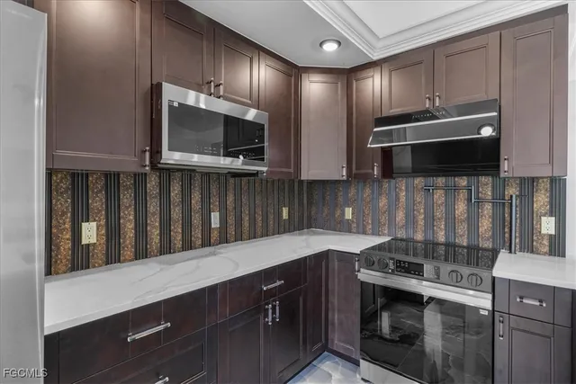 a kitchen with stainless steel appliances wooden cabinets and a stove top oven