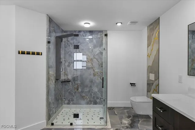 a bathroom with a shower a toilet and a sink